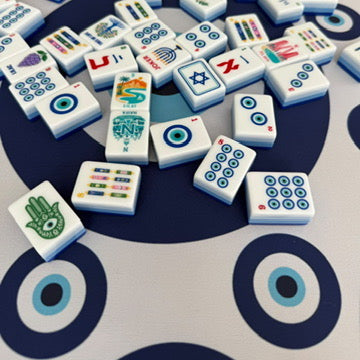 Close-up of mahjong tiles scattered on the Evil Eye mahjong mat