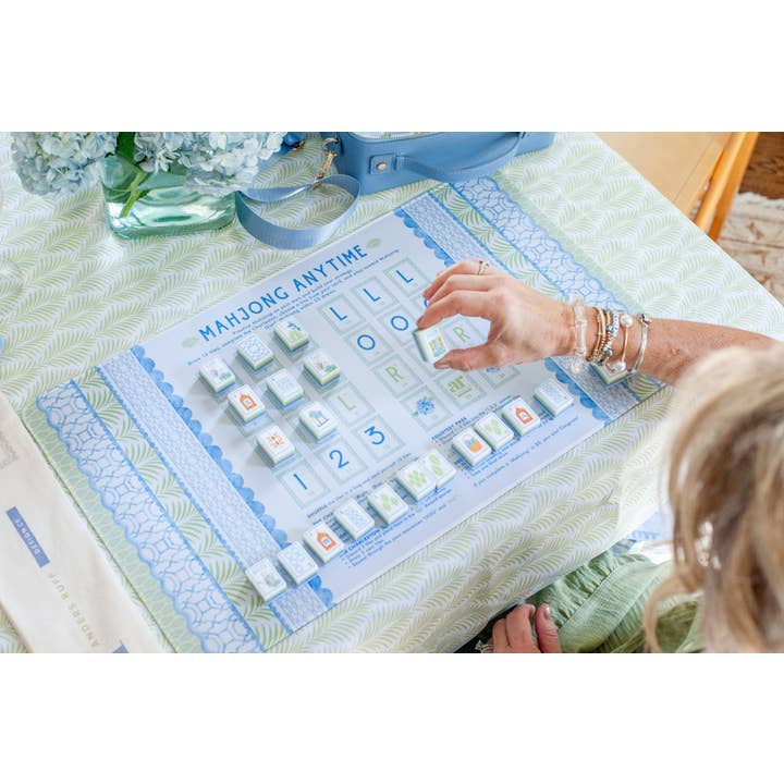 Player practicing solo mahjong on the House of Hydrangea mat — tiles on the printed Charleston layout