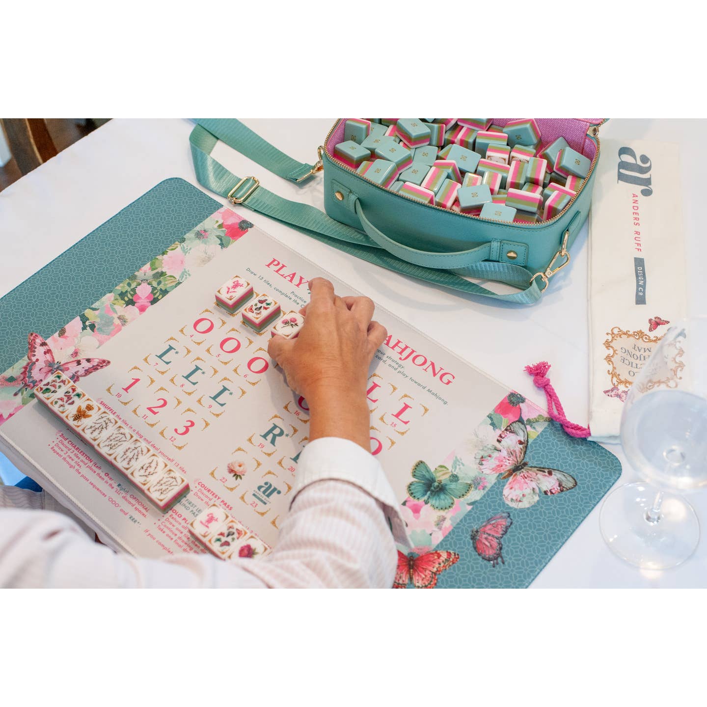 Hand placing tiles on the Mahj in Bloom solo play mat with tile bag